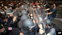 Pro-democracy protesters push Thai policemen with riot shields during a demonstration in Bangkok, Thailand, Thursday, Oct. 15, 2020. Thai police dispersed a group of protesters holding an overnight rally outside the prime minister's office. (AP…