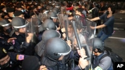 Pro-democracy protesters push Thai policemen with riot shields during a demonstration in Bangkok, Thailand, Oct. 15, 2020. 