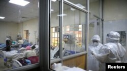 FILE - Medical staff dressed in protective suits talk to each other as they treat coronavirus disease patients at the COVID-19 ICU of Machakos Level 5 Hospital, in Machakos, Kenya, Oct. 28, 2020. 