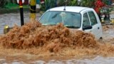 A car moves through a flooded road during heavy rains at Guwahati in the northeastern Indian state of Assam.