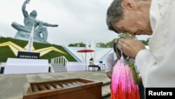 Shigeko Iwamoto, who survived the 1945 atomic bombing of Nagasaki, offers prayers for the victims in front of the Peace Statue in Nagasaki's Peace Park, August 9, 2012. 