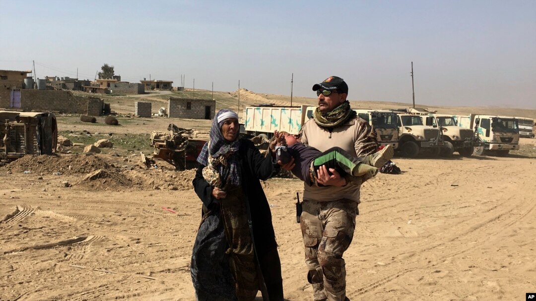 An Iraqi Army soldier helps displaced civilians as they flee their homes due to fighting between Iraqi security forces and Islamic State militants, on the western side of Mosul, Iraq, Tuesday, Feb. 28. 2017.