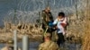 ARCHIVO - Migrantes son detenidos por funcionarios en la frontera entre Texas y México, el 3 de enero de 2024, en Eagle Pass, Texas. 