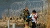 Un grupo de migrantes es detenido por oficiales en la frontera entre Texas y México el 3 de enero de 2024, en Eagle Pass, Texas.