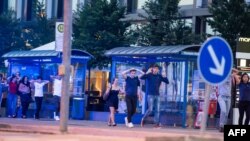 Evacuated people from the shopping mall walk with their hands up in Munich, July 22, 2016 following a shooting earlier.