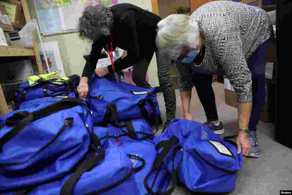 Las funcionarias electorales Sharon Krewson y Donna Nicolazzi desempacan bolsas azules con boletas despu&#233;s del d&#237;a de las elecciones en el edificio municipal de Kenosha, en Wisconsin, el 4 de noviembre de 2020.