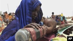 A mother quenches her malnourished child's thirst while waiting for food handouts at a health center in drought-stricken remote Somali region of Ethiopia, July 9, 2011.