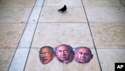 FILE - Masks depicting Israeli Prime Minister Benjamin Netanyahu and Israeli Defense Minister Benny Gantz lay on the ground during a protest against sending the country to its fourth elections in two years, in Tel Aviv, Dec. 2, 2020.