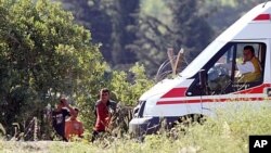 A group of Syrians wait next to a Turkish ambulance at the Syria-Turkey border inside Syria as they wait for the authorization to cross the border near the Turkish village of Guvecci in Hatay province, Turkey, June 9, 2011.