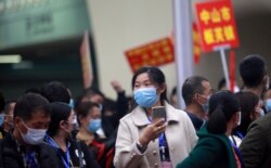 FILE - Migrant workers, wearing face masks to prevent the spread of coronavirus disease (COVID-19), arrive via a charter train from Jingzhou, Hubei province, at Guangzhou South Railway Station in Guangzhou, Guangdong province, China, March 19, 2020.