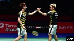 Pasangan ganda putra Marcus Fernaldi Gideon (kanan) dan Kevin Sanjaya Sukamuljo saat bertanding melawan Li Junhui dan Liu Yuchen dari China dalam laga final ganda putra di turnamen bulu tangkis Jepang Terbuka, 16 September 2018.