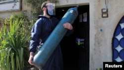 Arhiva - Volonter nosi bocu sa kiseonikom namenjenju zbrinjavanju pacijenata obolelih od koronavirusa, u Damasku, Sirija, 3. marta 2021.