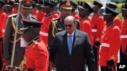 FILE - Sudan's then-President Omar al-Bashir inspects the guard of honor upon his arrival in Entebbe, Uganda, Nov. 13, 2017. Uganda says it will consider giving asylum to the deposed leader. 