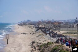 FILE—Displaced Palestinians trying to walk back from central Gaza Strip to northern Gaza Strip, April 14, 2024.