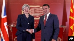 Perdana Menteri Inggris Theresa May (kiri) berjabat tangan dengan mitranya dari Macedonia, Perdana Menteri Zoran Zaev (kanan), menyusul pertemuan antara kedua pemimpin di Skopje, Macedonia, Kamis 17 Mei 2018.