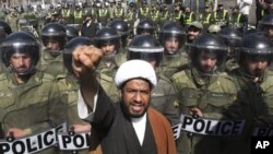 A Bahraini Shi'ite cleric chants slogans in a protest against Saudi and Bahraini leaders in front of the Saudi Embassy in Tehran, as Iranian police officers protect the Embassy, Iran, March 17, 2011