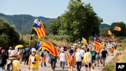 Pro-independence Catalan demonstrators march towards Vimbodi, northeastern Spain, July 20, 2020 during a protest against the visit of Spain's King Felipe VI and Queen Letizia.