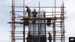 Workers stand on scaffolding at a road construction site in Beijing (File).