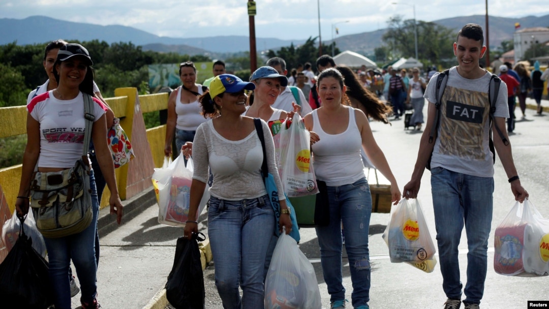 Warga Venezuela terlihat membawa kantong-kantong belanja saat mereka melewati perbatasan Kolombia-Venezuela di jempatan Simon Bolivar, setelah berbelanja dan memanfaatkan kesempatan setelah perbatasan di San Antonio del Táchira, Venezuela dibuka untuk sementara waktu.