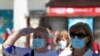 FILE - A woman wearing a protective face mask salutes as people hold a minute of silence during the last day of the official ten-day mourning of those who died of the coronavirus disease (COVID-19), at Puerta del Sol square in Madrid, June 5, 2020. 