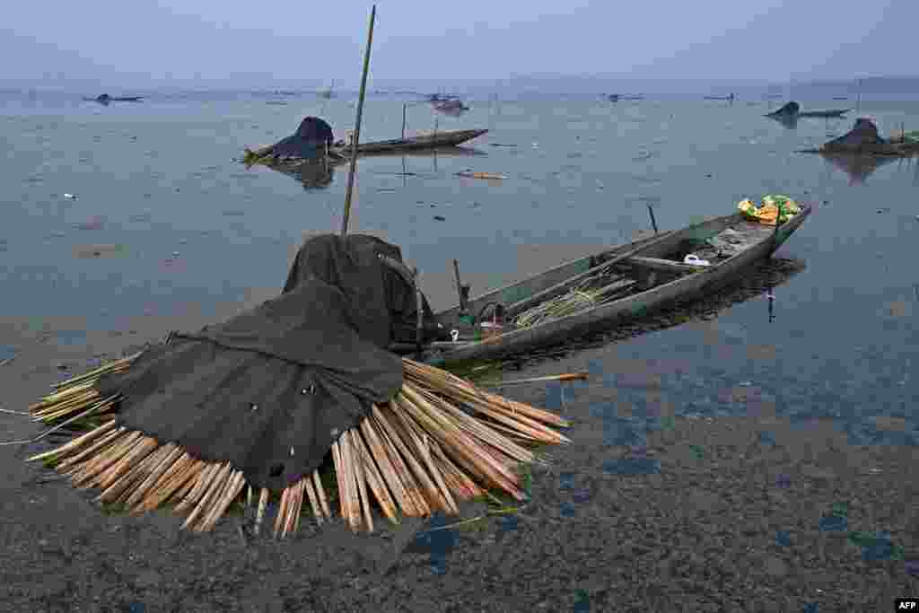 Fishermen use harpoons near a frozen portion of Anchar Lake on the outskirts of Srinagar, India.