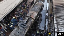 Firefighters and onlookers gather at the scene of a fiery train crash at Cairo's main railway station, Feb. 27, 2019.