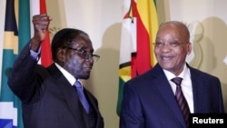 FILE - Zimbabwe's President Robert Mugabe (L) gestures as South Africa's President Jacob Zuma looks on at the end of a press briefing at the Union building in Pretoria, April 8, 2015.