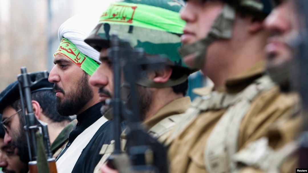 FILE - A cleric, who is member of Iran's Basij militia, attends a military parade to mark Basij week in front of the former U.S. embassy in Tehran, Nov. 25, 2011.