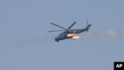 Military helicopter from Myanmar Air Force fires at a target during the first day of 'Sin Phyu Shin' joint military exercises Friday, Feb. 2, 2018, in Ayeyarwaddy delta region, Myanmar.