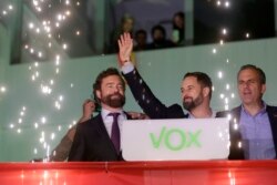 Santiago Abascal, leader of far-right Vox Party, waves to supporters as fireworks go off outside the party headquarters after the announcement of the general election first results, in Madrid, Nov. 10, 2019.