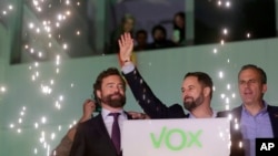 Santiago Abascal, leader of far-right Vox Party, waves to supporters as fireworks go off outside the party headquarters after the announcement of the general election first results, in Madrid, Spain, Nov. 10, 2019. 