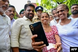 Para pemilih berfoto selfie dengan Presiden Sri Lanka Anura Kumara Dissanayake (4 dari kiri) saat ia meninggalkan tempat pemungutan suara setelah memberikan suaranya dalam pemilihan parlemen Sri Lanka di Kolombo pada 14 November 2024. (Foto: AFP)