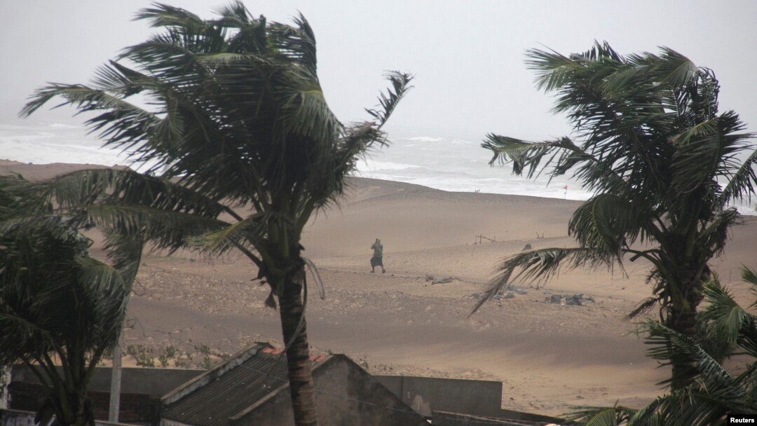 Seorang warga berjalan di pinggir pantai di Gopalpur di distrik Ganjam, Odisha, India (12/10).