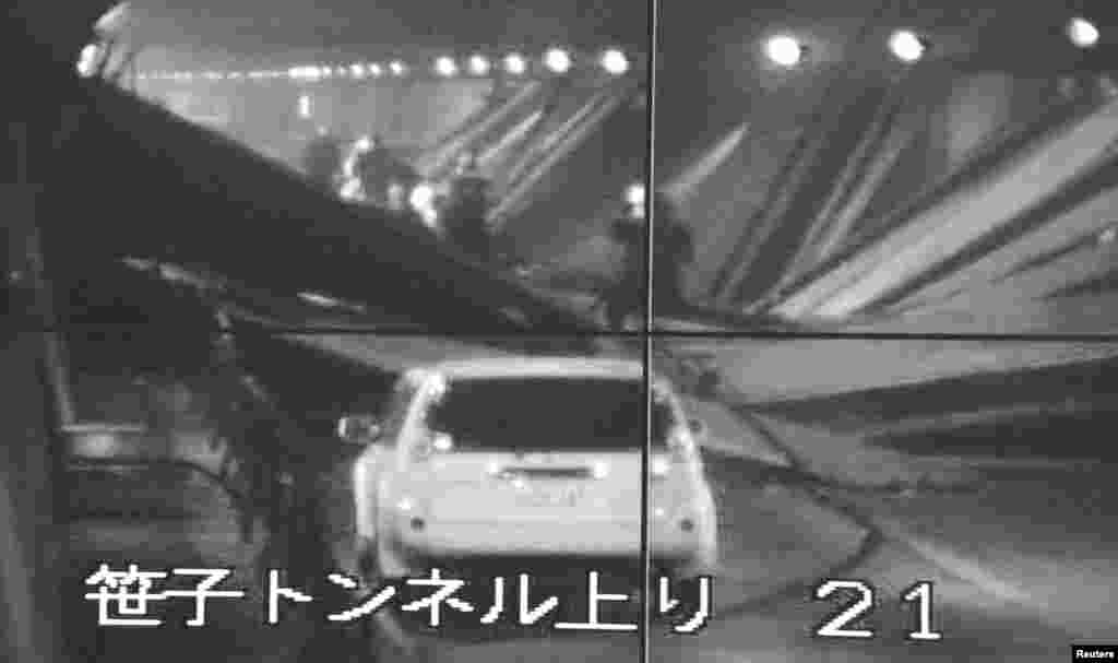 Màn hình theo dõi sinh hoạt trong hầm cho thấy một chiếc xe và một toan nhân viên cấp cứu trong đường hầm Sasago. (Kyodo)