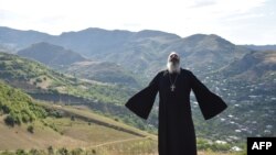 Priest Ter Abel prays for peace outside the village of Movses on the Armenian-Azerbaijani border on July 15, 2020. 