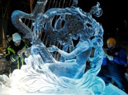 Artists from Russia's city of Yekaterinburg work on the ice sculpture "Muse of Victory" during the annual international festival of snow and ice sculptures "Magical Ice of Siberia", in Krasnoyarsk, Russia Feb. 28, 2019.