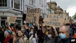 Supporters of the Rhodes Must Fall group, wearing protective masks against the spread of coronavirus, participate in a protest calling for the removal of a statue of Cecil Rhodes, a Victorian imperialist in southern Africa.