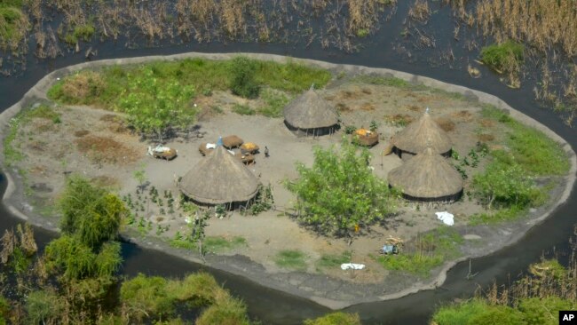 FILE - Thatched huts surrounded by floodwaters are seen from the air in Old Fangak county in Jonglei state, South Sudan on Nov. 27, 2020. The people of South Sudan are debating whether to restart the canal project. (AP Photo/Maura Ajak, File)