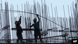 Construction laborers work at under construction residential building in Mumbai, India, Wednesday, May 31, 2023. (AP Photo/Rajanish Kakade)