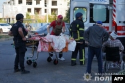 This photo taken and released by the Ukrainian National Police on Sept. 19, 2024, shows police officers and State Emergency Service of Ukraine rescuers as they transport victims of an airstrike on a geriatric center to an ambulance in Sumy, Ukraine.