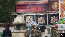 Chinese military personnel carrying fire extinguisher walks in front of Jokhang temple at Barkor Square in Lhasa, Tibet