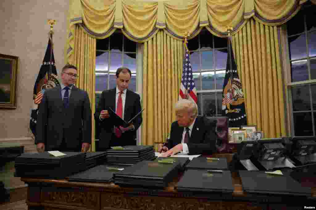 U.S. President Donald Trump signs pardons for January 6 defendants in the Oval Office at the White House on Inauguration Day in Washington.