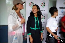 FILE - Boston mayoral candidates Annissa Essaibi George, left, and Michelle Wu, center, speak before the start of the Roxbury Unity Parade, in Boston's Roxbury neighborhood, July 18, 2021.