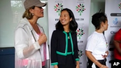 Dua kandidat walikota Boston Annissa Essaibi George (kiri) dan Michelle Wu (tengah), tampak berbincang sebelum parade Roxbury Unity berlangsung di kota Boston pada 18 Juli 2021. (Foto: AP)