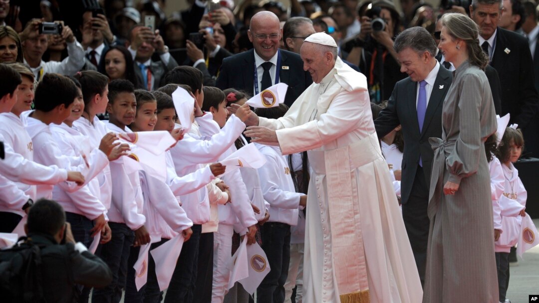 Presiden Kolombia Juan Manuel Santos, dan ibu negara Kolombia Maria Clemencia Rodriguez mendampingi Paus Fransiskus menyalami anak-anak yang menyambut kedatangannya di bandara El Dorado, Bogota, Kolombia (6/9). 