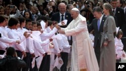 Presiden Kolombia Juan Manuel Santos, dan ibu negara Kolombia Maria Clemencia Rodriguez mendampingi Paus Fransiskus menyalami anak-anak yang menyambut kedatangannya di bandara El Dorado, Bogota, Kolombia (6/9). 