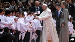 Colombia's President Juan Manuel Santos, second from right, and his wife Maria Clemencia Rodriguez accompany Pope Francis who is greeted by children upon his arrival to El Dorado airport in Bogota, Colombia, Sept. 6, 2017.