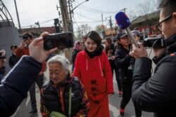 FILE - Li Wenzu, wife of detained Chinese rights lawyer Wang Quanzhang, is followed by friends and media near a Supreme People's Court complaints office in Beijing, China, on April 4, 2018.