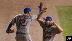Juan Lagares (12) de los NY Mets celebra con Daniel Murphy (28) luego del tercer juego de la Serie de Campeonato de la Liga Nacional contra los Cachorros de Chicago, el martes 20 de octubre, de 2015.
