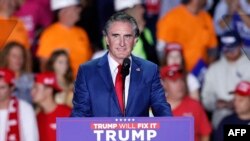 Arxiv fotosu - Şimali Dakota ştatının qubernatoru Daq Burqum seçki günü öncəsi ABŞ-ın keçmiş prezidenti və Respublikaçılar Partiyasından prezidentliyə namizəd Donald Trampın Miçiqan ştatında Qrand Rapidsdə Van Andel Arenada son kampaniya mitinqində çıxış edir, 4 noyabr 2024.